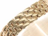 a close up of a gold bracelet on a white surface