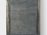 an old metal frame with a blackboard in the middle of it