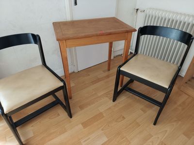 two chairs and a table in the corner of a room