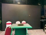 une table et des chaises vertes dans une pièce aux murs noirs