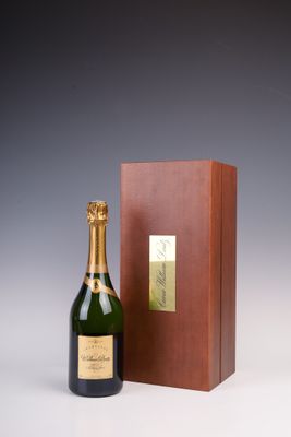 une bouteille de champagne devant une boîte en bois
