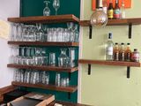 a wooden table with glasses and bottles on it in the kitchen