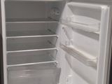 un réfrigérateur dont la porte est ouverte dans une pièce