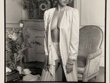 photographie en noir et blanc d'une femme posant dans une pièce où se trouve une chaise
