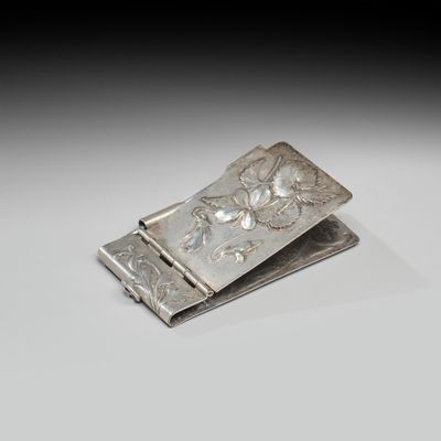 pince à billets en argent ornée d'un motif floral sur fond blanc