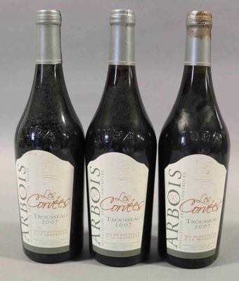trois bouteilles de vin posées sur une table l'une à côté de l'autre