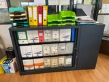 many files and folders on a shelf in the office