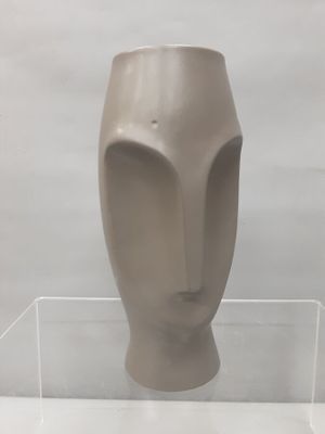 une sculpture représentant une tête, exposée dans une vitrine