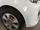 a close up of a white car with a denting on it