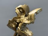 une sculpture en bronze représentant une femme tenant un livre