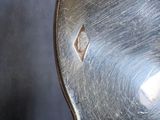 a close up of a silver spoon with a hole in it