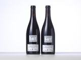 two bottles of wine sitting on top of a table next to each other
