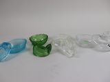 several different colored glass objects are lined up on a white surface