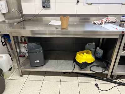 a metal work bench with a yellow bucket on it