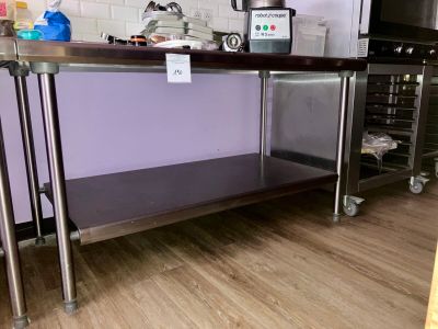 une cuisine équipée d'une table en inox et d'un micro-ondes