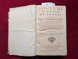 un livre ouvert posé sur un tissu rouge, d'où dépasse un bout de papier