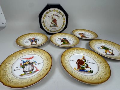 six assiettes à bords dorés et une horloge sur une table