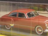 a red toy car in a clear display case