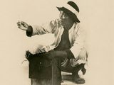a black and white photo of a man sitting on a suitcase