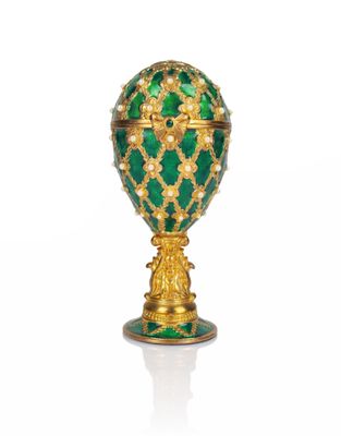 an image of a green and gold faber egg on a stand