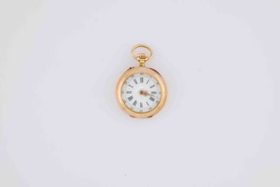 a close up of a pocket watch on a white surface
