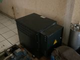 un micro-ondes noir posé sur une étagère en bois dans une pièce
