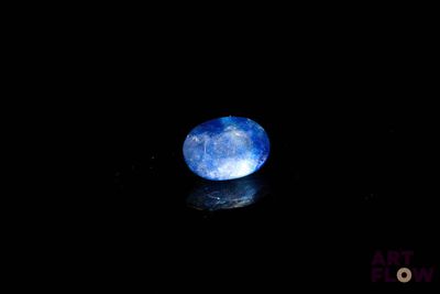 gros plan d'une pierre bleue sur une surface noire
