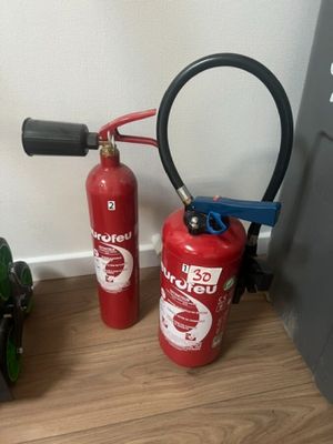 two fire extinguisors sitting next to each other on the floor