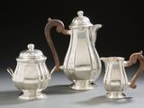 three pieces of silver tea and coffee set on a table