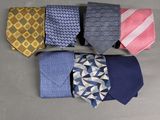 four different colored ties laid out in a row on a gray surface