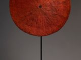 an image of a sculpture of a red disk on a black stand