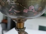 a metal bowl on a stand on a table