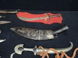 many different types of knives on a black surface