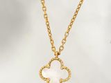 un collier en or orné d'un pendentif en forme de fleur blanche