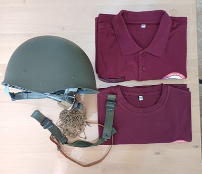 a helmet, t - shirt and other items laid out on a table