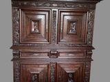 une grande armoire en bois dont les portes sont ornées de sculptures