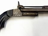 un vieux pistolet posé sur une surface blanche