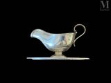 an image of a silver gravy on a plate against a black background