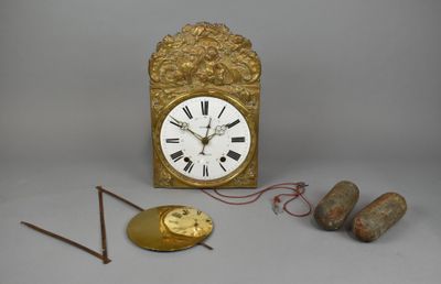 une horloge dorée avec des chiffres romains, à côté de deux aiguilles