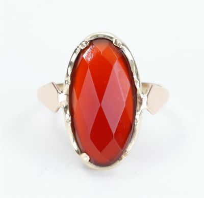 a close up of a ring with a red stone in it