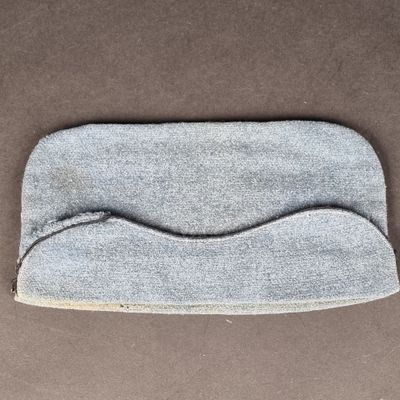 un gros plan d'un masque pour les yeux gris posé sur une surface marron