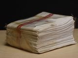 a stack of folded papers sitting on a wooden table