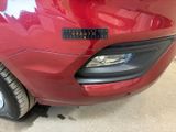 a close up of a red car with a sticker on it