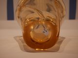 a glass vase with a label on it sitting on a table