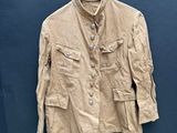 une veste beige suspendue à un cintre contre un mur bleu