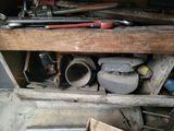 some tools are sitting on a wooden shelf in a garage