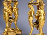pair of gilded bronze candlesticks with cherenshes and cherenshes on them