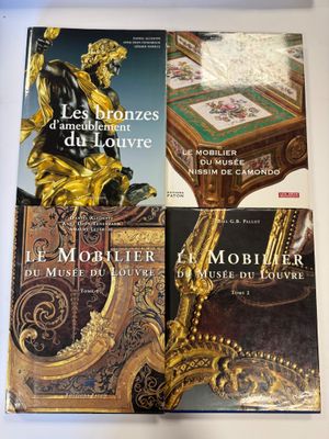 trois livres posés sur une table surmontée d'une statue en or