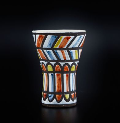 un gros plan d'un vase coloré posé sur une surface noire
