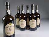 plusieurs bouteilles de vin sont alignées sur une surface blanche